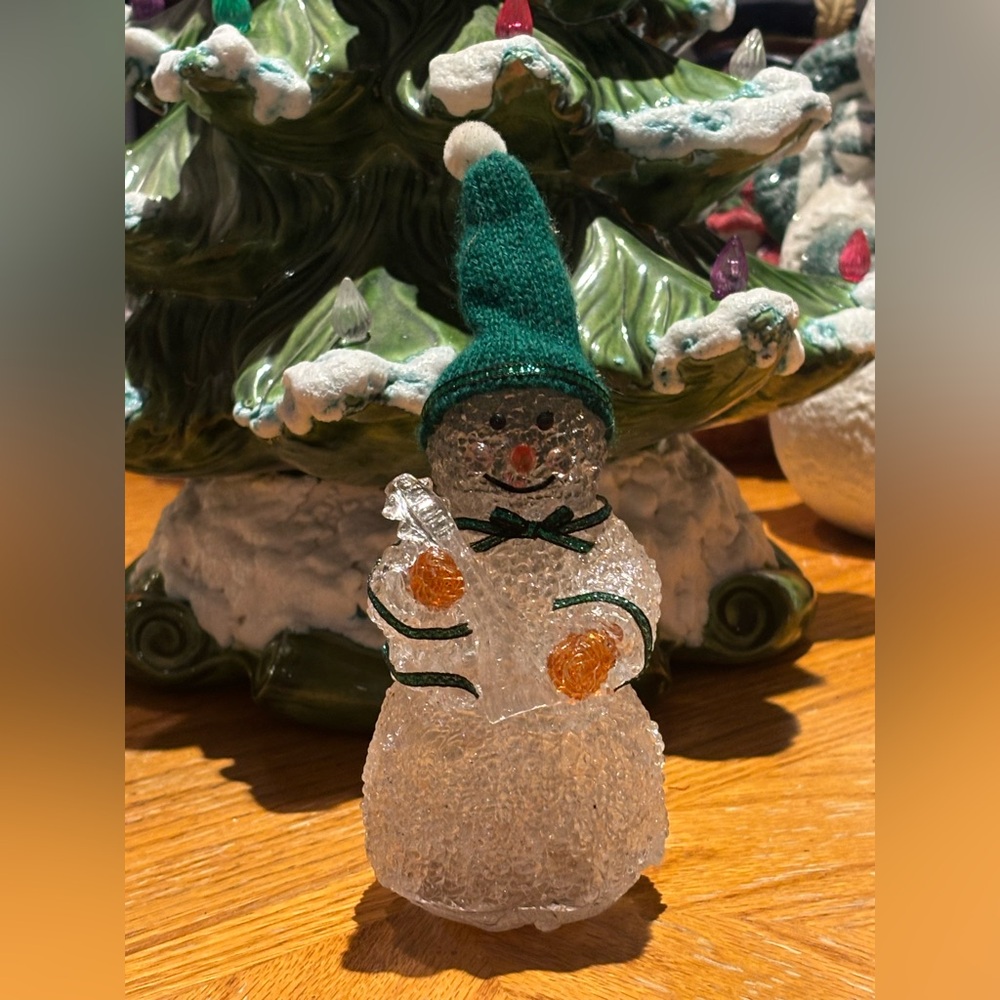 Cheerful Christmas Snowman Figurine with Green Hat Holding a String Instrument